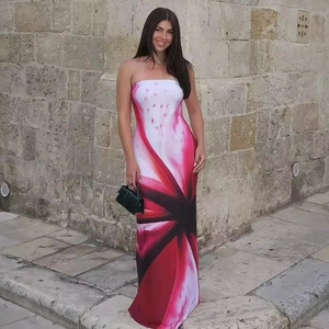 Detail of slim fit strapless maxi dress with artistic print against a stone wall