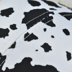 Close-up of cow print baseball cap featuring high-quality white double stitching details