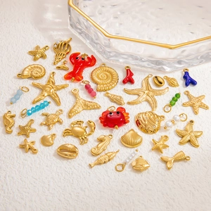 Flat lay of 18k gold ocean-themed charms including starfish, shells, and seahorses