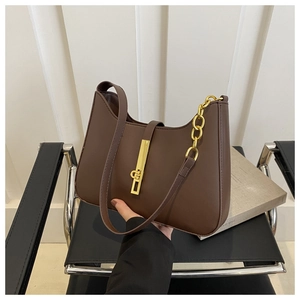 Detail of dark brown leather underarm bag with gold piston buckle and metal chain strap
