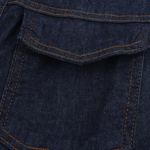 Gros plan détaillé du tissu denim bleu foncé avec double couture orange sur la poche