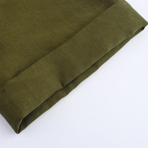 Detailed macro view of the green twill fabric texture and material of the midi dress