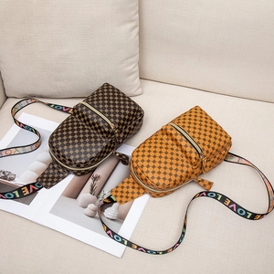 Retro polka dot crossbody chest bags in brown leather with LOVE printed straps on sofa