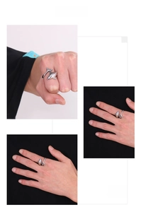 Detailed view of polished silver dolphin ring with blue eyes on model finger