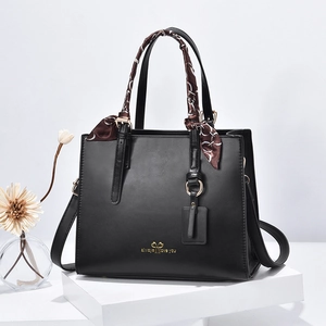 Minimalist black PU leather tote bag with gold accents and patterned handle scarf