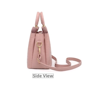 Side view of pink crocodile pattern tote bag with gold hardware and shoulder strap