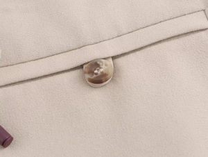 Detailed close-up of ribbed halter dress khaki fabric and amber textured button