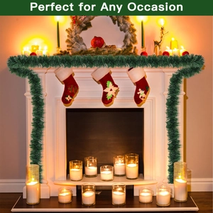 Close-up of deep green Christmas garland wrapped on fireplace with festive stockings