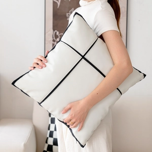 Minimalist white PU leather cushion with black geometric piping held by a model
