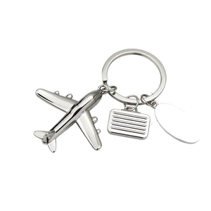 Silver metal airplane keychain with miniature suitcase and customizable oval engravable tag