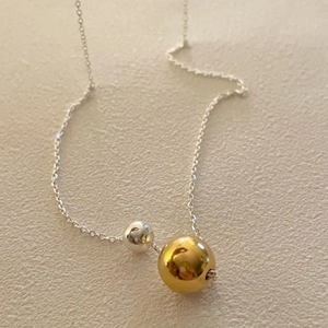 Detail of silver chain with double metallic beads in silver and gold minimalist finish