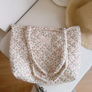 Close-up of pink floral quilted cotton tote bag with French label and soft handles
