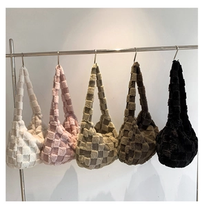 Detail showing five colors of plush woven checkered shoulder bags on a metal display rack