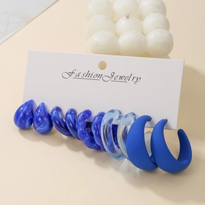 Macro view of blue resin earring set featuring teardrop and C-shape hoop designs