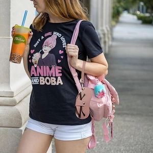 Close-up of a pink cat-shaped leather glasses case hanging on a girl's stylish pink backpack