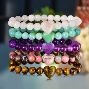Close-up of natural stone beaded bracelets with heart pendants in assorted colors