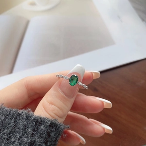 Detail of S925 sterling silver ring with oval emerald zircon and marquise side stones