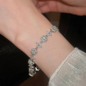 Gros plan d'un bracelet fleur en zircon bleu clair au poignet avec finition argentée