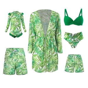 Flat lay of family matching swimwear with green tropical palm leaf print pattern