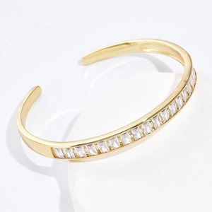 Minimalistisches Armreif mit 18K Vergoldung und Zirkonia auf weißem Steinsockel