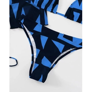 Detail of three-piece bikini with blue geometric print mesh cover-up and high cut bottoms
