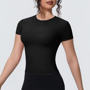 Détail macro du t-shirt de yoga noir ajusté montrant le tissu respirant et la couture