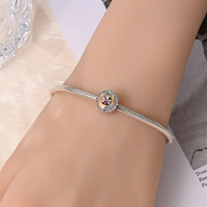 Bracciale a catena serpente in argento con ciondolo floreale iridescente sul polso