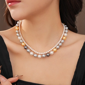 Collier double rang de perles grises blanches et dorées porté par un mannequin