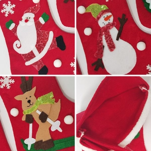 Detailed view of red felt Christmas stockings with Santa, snowman and reindeer embroidery