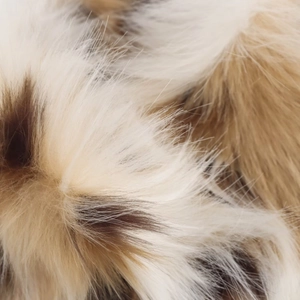 Macro shot of faux fur texture showing soft white and brown multi-color synthetic fibers