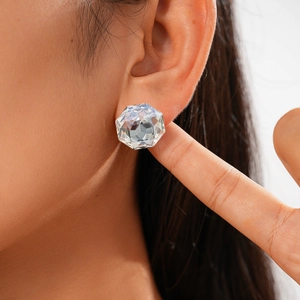 Close-up of geometric faceted glass stud earring worn on model for a trendy look