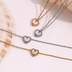 Vue détaillée des pendentifs cœur en nacre avec bordure perlée en finition or et argent