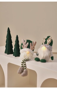 Detail of glowing green Christmas gnome dolls with LED lights and sequin hats
