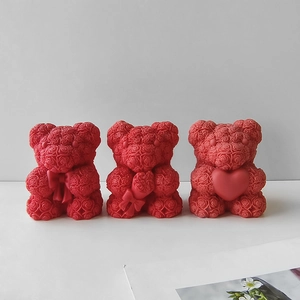 Three red rose bear candles with bow and heart designs on a clean white background
