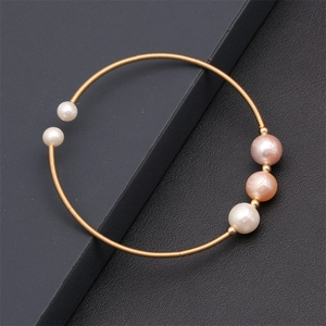 Detail of gold spiral bracelet with mixed white and pink natural freshwater pearls