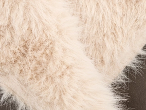 Detailed macro view of soft beige faux fur texture on this stylish reversible winter coat