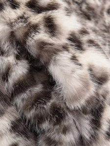 Detail der hochdichten Leopard-Kunstpelzstruktur mit weichen grauen und weißen Fasern