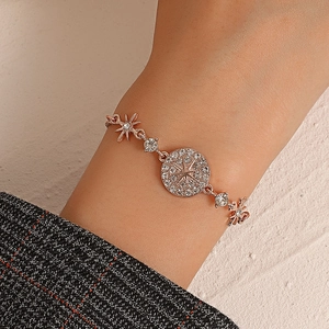Macro view of rose gold bracelet with crystal-paved star medallion and celestial charms