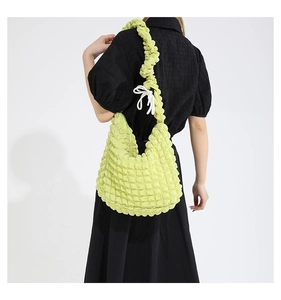 Detail of light green pleated bubble fabric shoulder bag with ruffled strap and drawstring