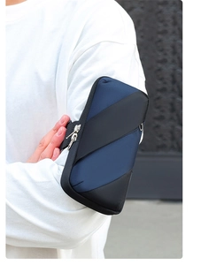 Detail of blue and black dual-zipper sports arm bag worn on arm for outdoor running
