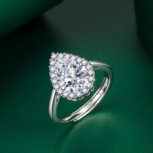 Elegant pear cut emerald green gemstone ring with halo diamonds and adjustable silver band