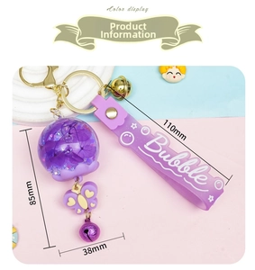 Detail of purple floating key ring with glitter flower charm and bells for bags