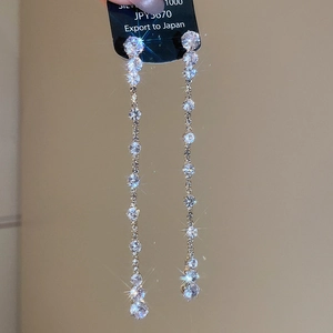 Macro detail of silver drop earrings with tassel zircon stones and silver 1000 hallmarked tag