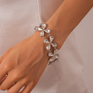 Detail of floral silver necklace with waterdrop crystals on elegant white satin