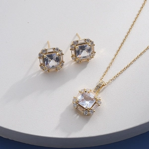 Detailed view of square-cut zircon jewelry set with necklace and earrings in gold finish