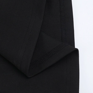 Close-up of black knitted fabric showing premium double-needle stitching and seam details