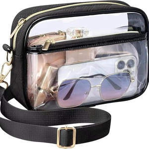 Clear PVC crossbody bag for travel with black fabric strap and gold metal hardware