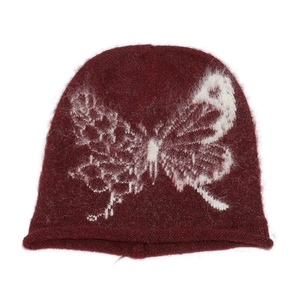 Close-up of deep red knit beanie featuring a white butterfly jacquard pattern and soft texture