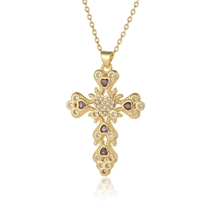 Detailed shot of a gold cross pendant with purple heart gems and clear zircon stones