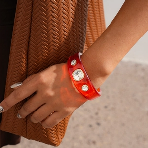 Close-up of a red translucent resin bangle with sparkling crystal rhinestone inlays